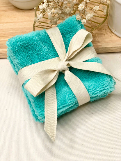 Gros plan sur la texture ultra douce de l'éponge de bambou et le tissu coton certifié Oeko-Tex d'un carré démaquillant artisanal